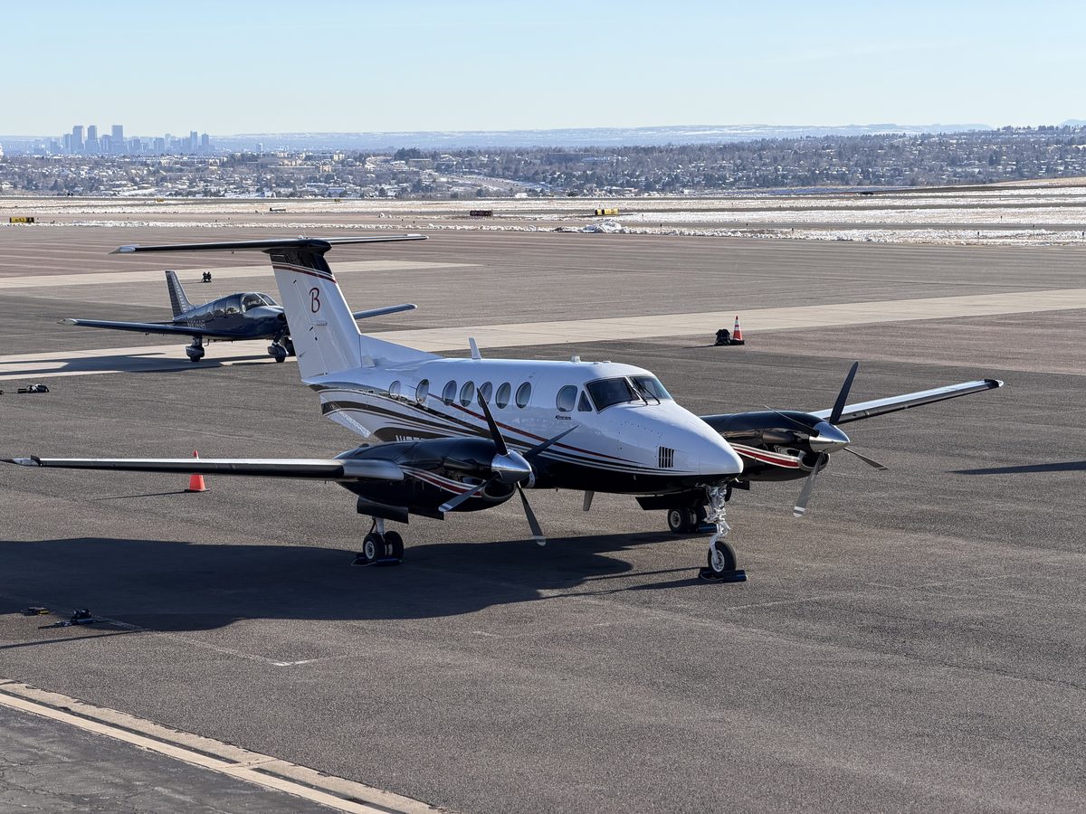 Beechcraft King Air turboprop parked on the ramp at Rocky Mountain Metropolitan Airport with the Denver skyline in the background